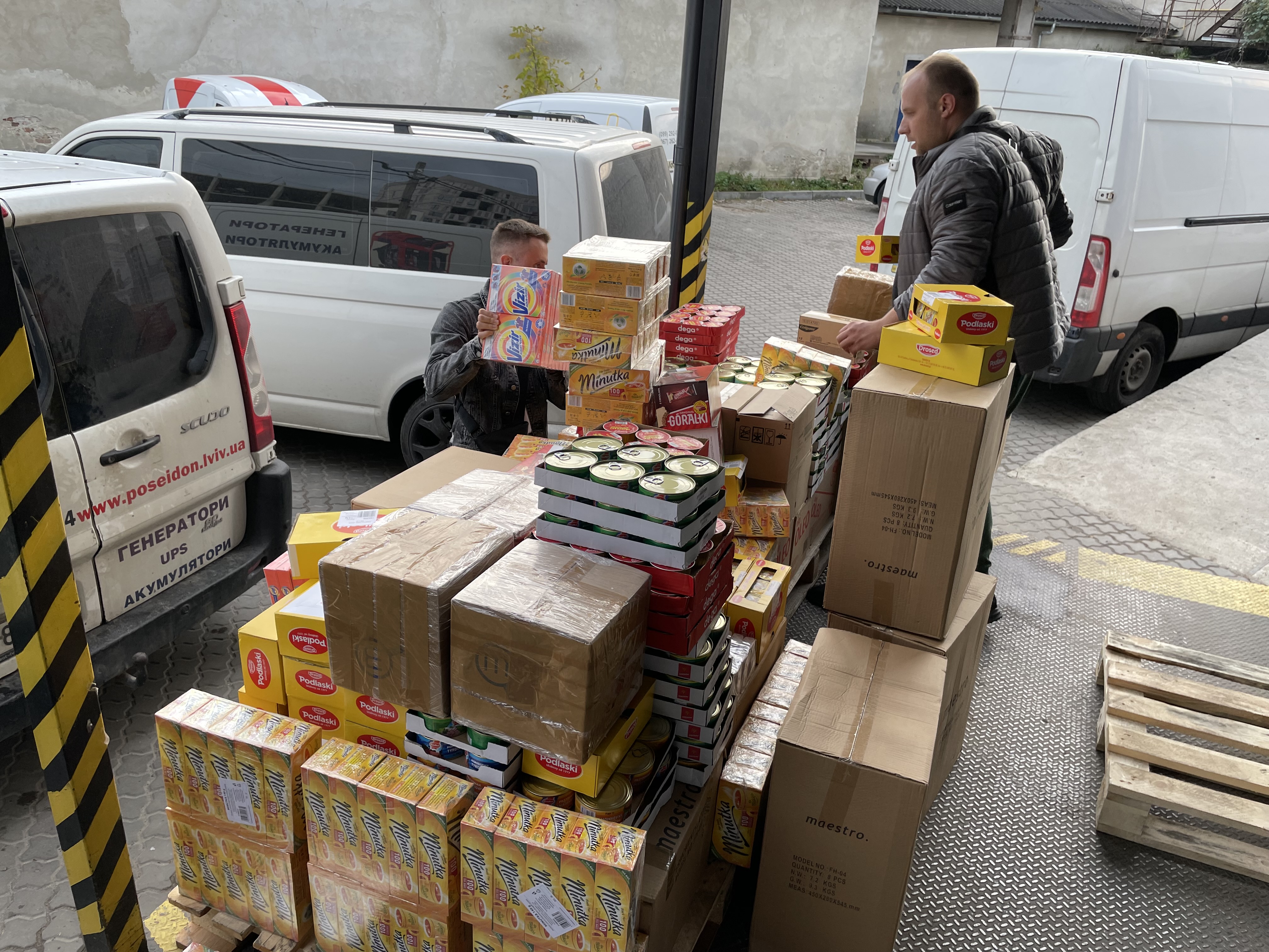 Men loading vans with pallets of food for distribution